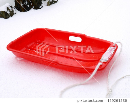 A red sled placed on the piled-up snow 139261286