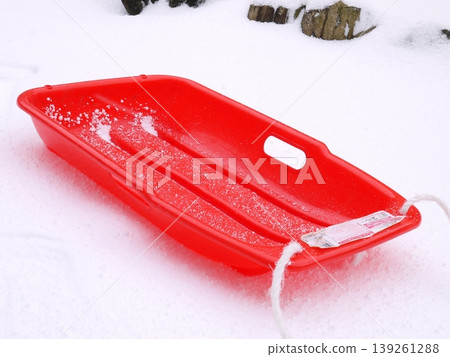 A red sled placed on the piled-up snow 139261288