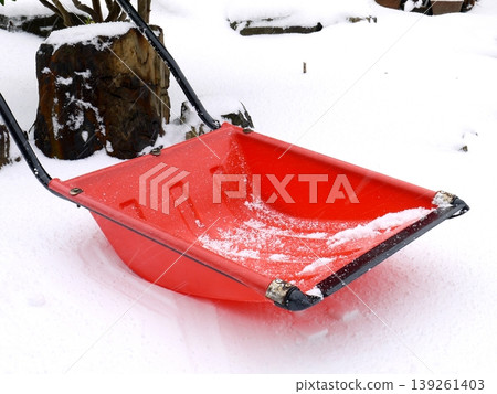 A red snow shovel placed on top of the accumulated snow 139261403