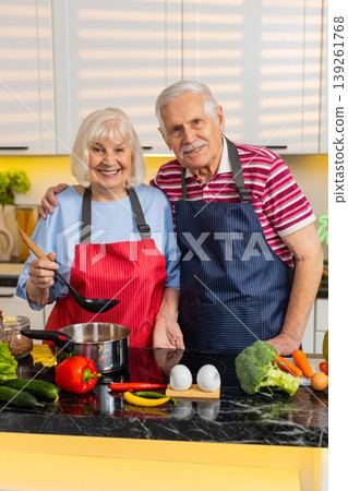 Senior old woman man cooking healthy soup in home kitchen tasting and seasoning with love together 139261768