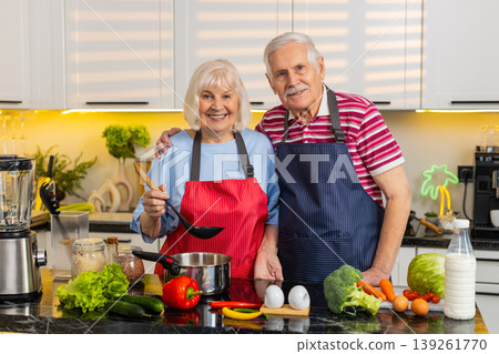 Senior old woman man cooking healthy soup in home kitchen tasting and seasoning with love together Senior old woman man cooking healthy soup in home kitchen tasting and seasoning with love together 139261770