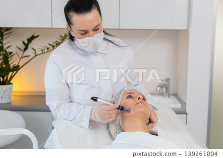 Microneedling dermapen mesotherapy for woman face regeneration by cosmetologist in beauty clinic spa Microneedling dermapen mesotherapy for woman face regeneration by cosmetologist in beauty clinic spa 139261804