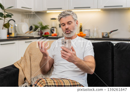 Middle-aged man practices language phrases with headphones on smartphone app repeats and feels proud Middle-aged man practices language phrases with headphones on smartphone app repeats and feels proud 139261847