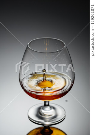 Drop of brandy fall into a glass. Drop of brandy fall into a glass. 139261871
