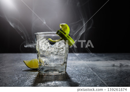 Vodka with lime and ice cubes in a fogged up glass. Vodka with lime and ice cubes in a fogged up glass. 139261874