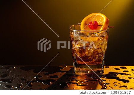 Old fashioned cocktail in a sweating glass on a wet black table. 139261897