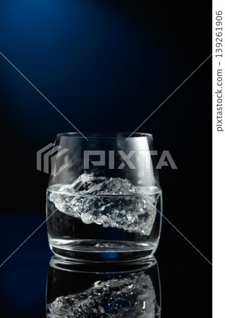 Vodka with ice on a black reflective background. Vodka with ice on a black reflective background. 139261906