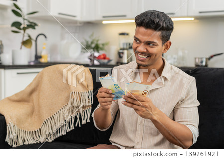 Indian man counts euro cash happy makes money gesture plans dream purchase savings bonus invest plan Indian man counts euro cash happy makes money gesture plans dream purchase savings bonus invest plan 139261921