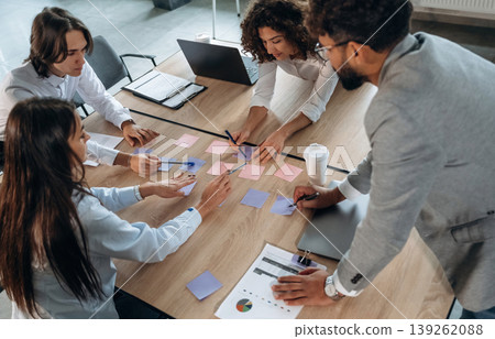 Blue and pink colored. Office workers are by the table with paper stickers, brain storming Blue and pink colored. Office workers are by the table with paper stickers, brain storming 139262088