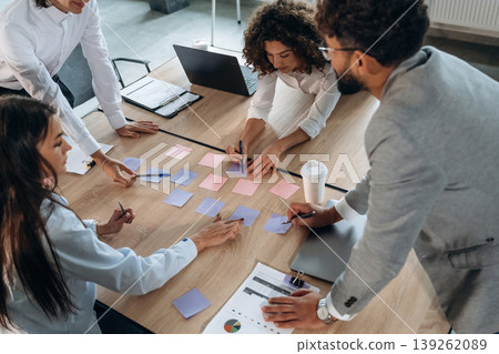 Blue and pink colored. Office workers are by the table with paper stickers, brain storming Blue and pink colored. Office workers are by the table with paper stickers, brain storming 139262089