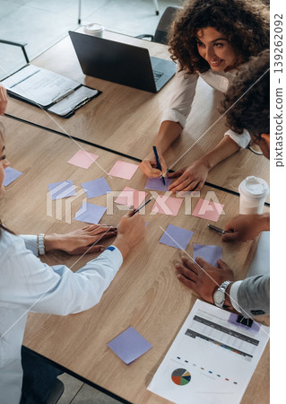 Brainstorming process. Office workers are by the table with paper stickers 139262092