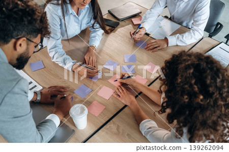 Brainstorming process. Office workers are by the table with paper stickers 139262094