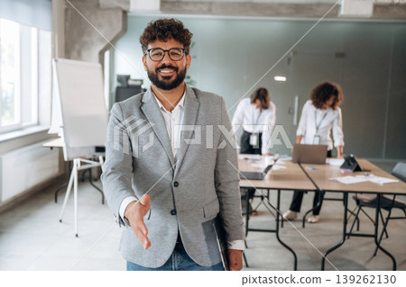 Giving a hand to shake. Group of people are working in the office together as a team Giving a hand to shake. Group of people are working in the office together as a team 139262130