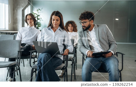 Two employees are talking to each other. People are sitting on the meeting, education presentation, business conception Two employees are talking to each other. People are sitting on the meeting, education presentation, business conception 139262254
