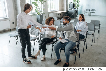 Taking the documents. People are sitting on the meeting, education presentation, business conception Taking the documents. People are sitting on the meeting, education presentation, business conception 139262266
