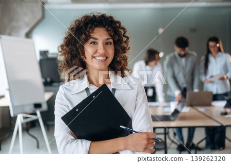 Positive facial expression, standing and smiling. Group of people are working in the office together as a team Positive facial expression, standing and smiling. Group of people are working in the office together as a team 139262320