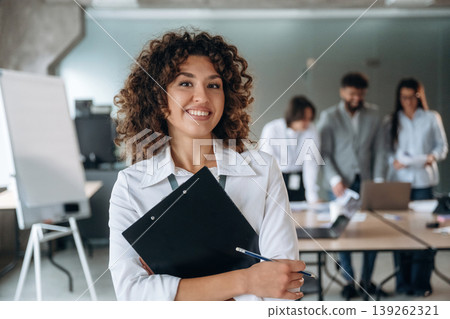 Positive facial expression, standing and smiling. Group of people are working in the office together as a team Positive facial expression, standing and smiling. Group of people are working in the office together as a team 139262321