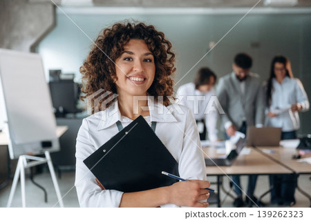 Positive facial expression, standing and smiling. Group of people are working in the office together as a team Positive facial expression, standing and smiling. Group of people are working in the office together as a team 139262323