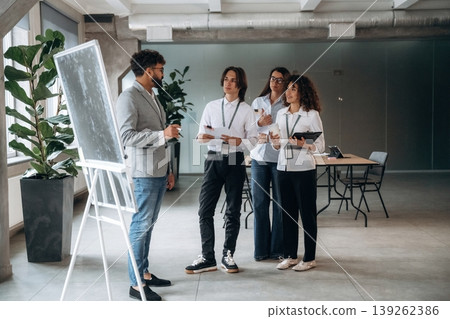 Explaining the problem with a project. Four office workers are together, employees at work Explaining the problem with a project. Four office workers are together, employees at work 139262386