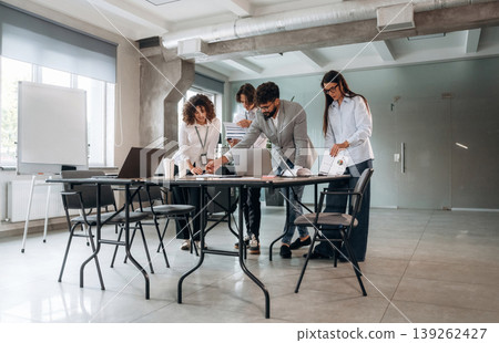 Natural lighting. Group of people are working in the office together as a team Natural lighting. Group of people are working in the office together as a team 139262427