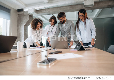 Busy day, by the table. Group of people are working in the office together as a team Busy day, by the table. Group of people are working in the office together as a team 139262428