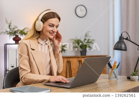Businesswoman types report with earphones calm music focus rhythm nod focused look productive flow Businesswoman types report with earphones calm music focus rhythm nod focused look productive flow 139262561