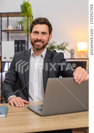 Middle-aged businessman opens laptop with big smile starts typing fast fresh start of new work day 139262568