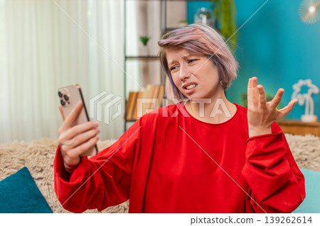 Woman making angry emotional video call argument on smartphone, gesturing irritated annoyed reaction 139262614