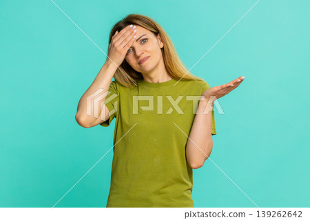 Woman making facepalm and rubbing forehead showing disappointment regret sudden realization moment Woman making facepalm and rubbing forehead showing disappointment regret sudden realization moment 139262642