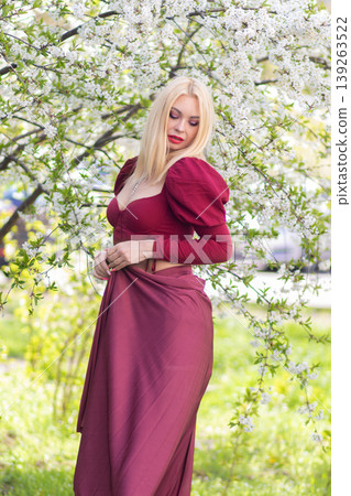 Blonde Woman Side Pose With Burgundy Skirt In Blossoms Blonde Woman Side Pose With Burgundy Skirt In Blossoms 139263522