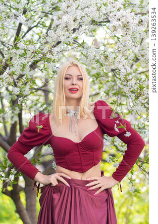 Smiling Blonde Woman With Hands On Hips In Blossoms Smiling Blonde Woman With Hands On Hips In Blossoms 139263534
