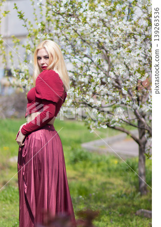 Blonde Woman Looking Over Shoulder In Spring Orchard Blonde Woman Looking Over Shoulder In Spring Orchard 139263536