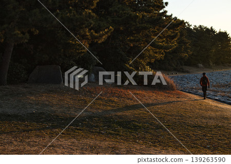 日出時的葛西臨海公園:晨曦照亮了沿著小路行走的人們的剪影。 日出時的葛西臨海公園:晨曦照亮了沿著小路行走的人們的剪影。 139263590