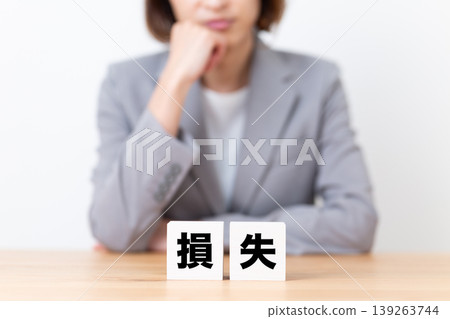 一位身穿西裝的中年女性正苦於應對虧損困境。 139263744