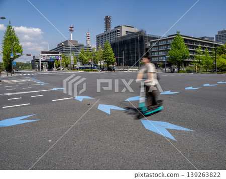A LUUP (electric scooter) riding on the bicycle navigation line within an intersection. A LUUP (electric scooter) riding on the bicycle navigation line within an intersection. 139263822