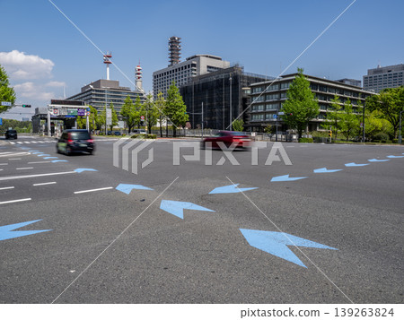 A road scene featuring a busy intersection with multiple cars and a designated bicycle navigation line. A road scene featuring a busy intersection with multiple cars and a designated bicycle navigation line. 139263824