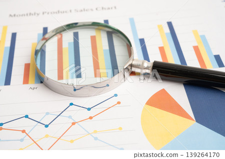 Magnifying glass on charts graphs paper. 139264170
