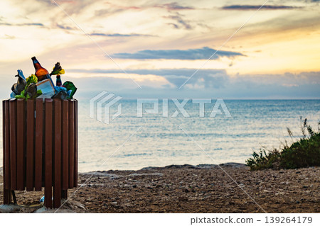 Beach with garbage bin full of trash 139264179