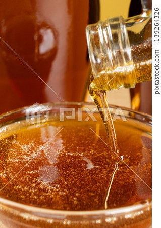 Pouring fresh maple syrup into a glass bowl 139264326