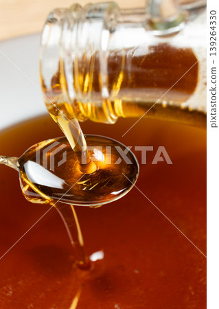 Natural Organic Maple Syrup Poured From Glass Bottle Into Spoon Natural Organic Maple Syrup Poured From Glass Bottle Into Spoon 139264330