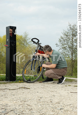 Maintenance of a mountain bike at a public repair pillar. Maintenance of a mountain bike at a public repair pillar. 139264373
