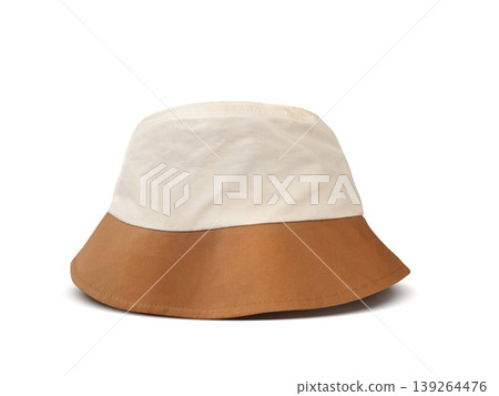 A white and brown bucket hat is placed on a white floor. A white and brown bucket hat is placed on a white floor. 139264476