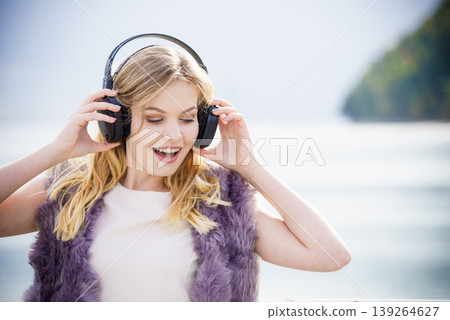 Happy woman wearing headphones outdoor Happy woman wearing headphones outdoor 139264627