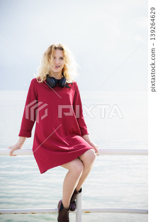 Woman wearing red dress and headphones 139264629