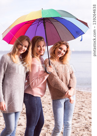 Three women under colorful umbrella Three women under colorful umbrella 139264638