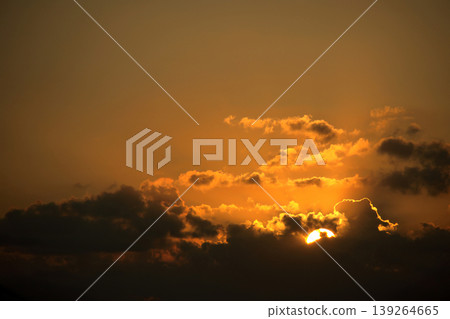 Dramatic Sunset Sky with Golden Sun and Dark Clouds. Intense, beautiful nature background. Dramatic Sunset Sky with Golden Sun and Dark Clouds. Intense, beautiful nature background. 139264665