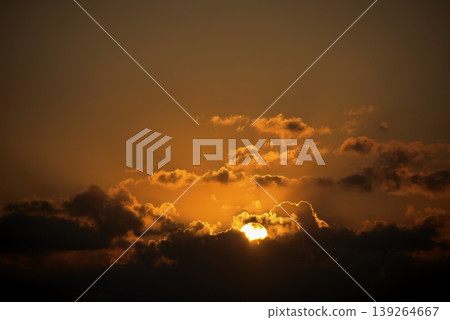 Dramatic Sunset Sky with Golden Sun and Dark Clouds. Intense, beautiful nature background. Dramatic Sunset Sky with Golden Sun and Dark Clouds. Intense, beautiful nature background. 139264667