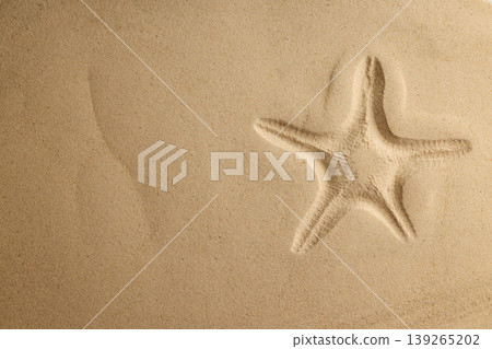 A starfish lies in the sand with footprints nearby A starfish lies in the sand with footprints nearby 139265202