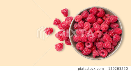 Bowl filled with fresh raspberries with some scattered around Bowl filled with fresh raspberries with some scattered around 139265230