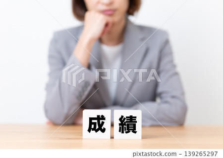 A middle-aged woman in a suit is troubled by her academic performance. A middle-aged woman in a suit is troubled by her academic performance. 139265297